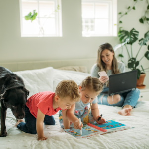 "Woman working from home with her kids and dog, balancing work from home and family life."