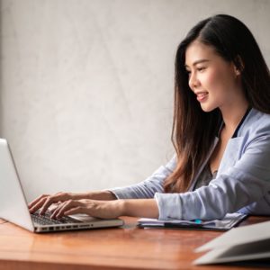 "Woman working from home on her computer, balancing work from home and family life."