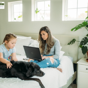 Woman working from home with her child and dog by her side, balancing family life and career."