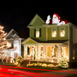 "A beautifully decorated house with Christmas lights and Santa Claus on the roof, creating a festive holiday scene."