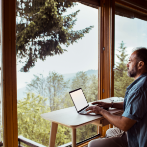 "A man working remotely from home at a scenic wilderness location, highlighting remote data entry jobs in 2024."